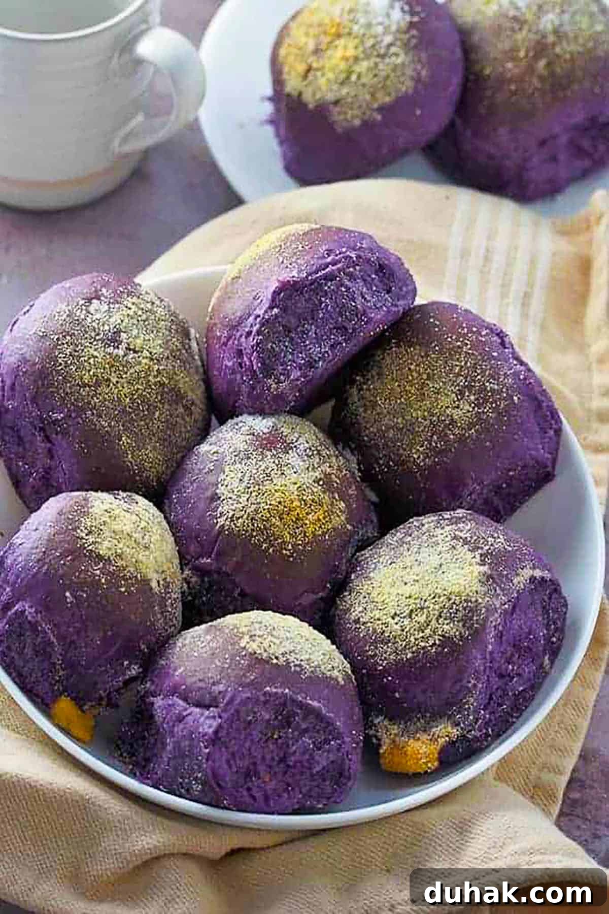 Ube Cheese Pandesal Recipe: Soft Filipino Purple Yam Rolls 2 ube cheese pandesal on a white plate.