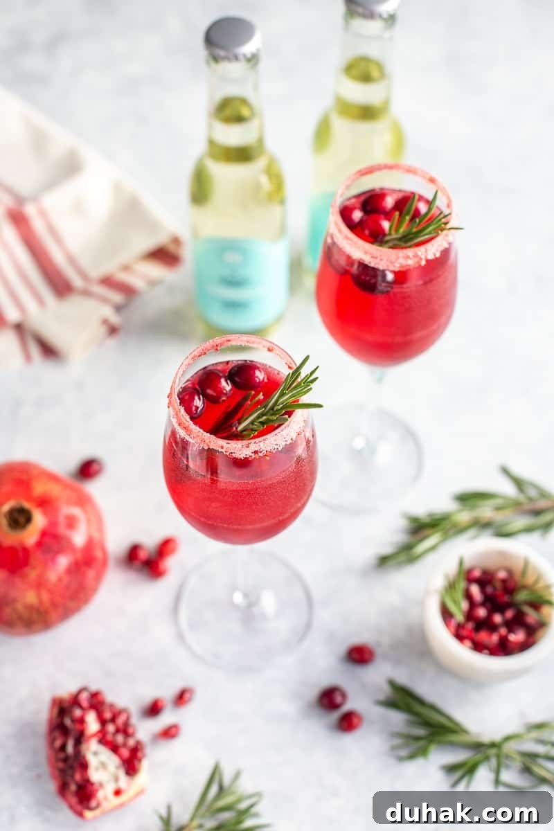 Prosecco drink with cranberries and rosemary in a glass flute