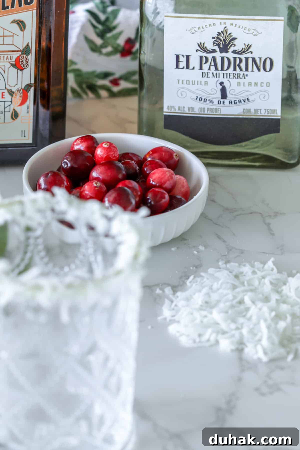 Cranberries and tequila on table.