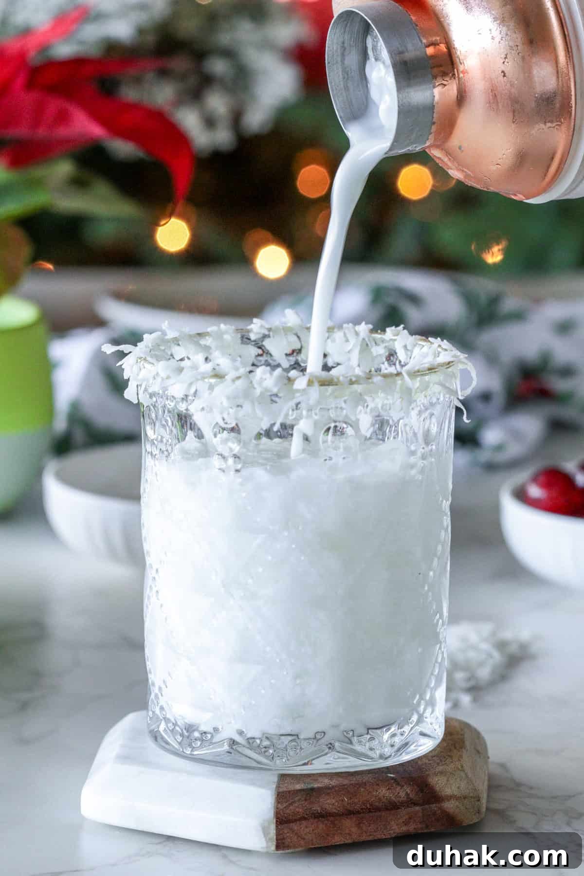 Pouring a white winter margarita into glass.