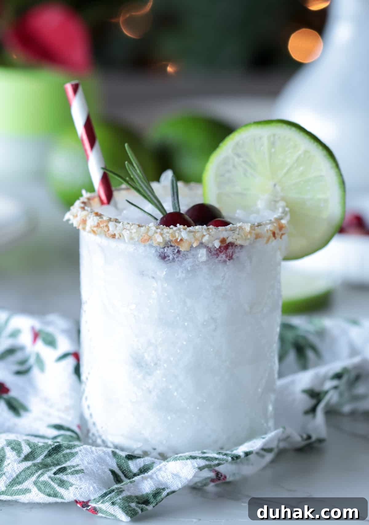 White margarita on table with straw and lime wheel.