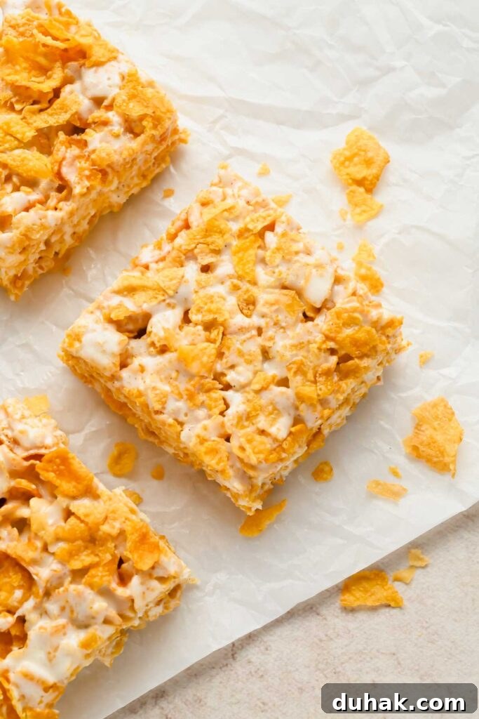 cornflake rice krispies cut into squares on white parchment.