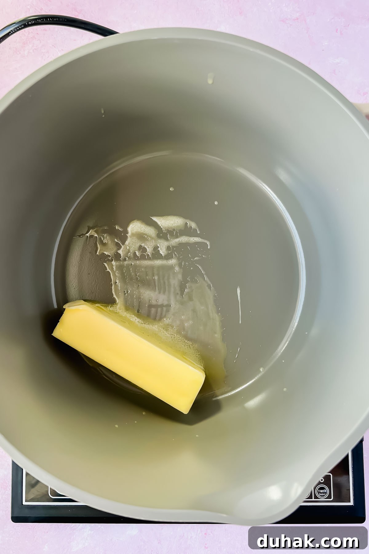butter melting in gray sauce pot.