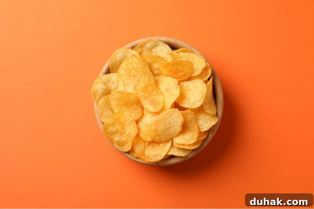 Stop Snacking: Dietitian-Backed Strategies to Curb Cravings 2 A bowl of chips on an orange background.
