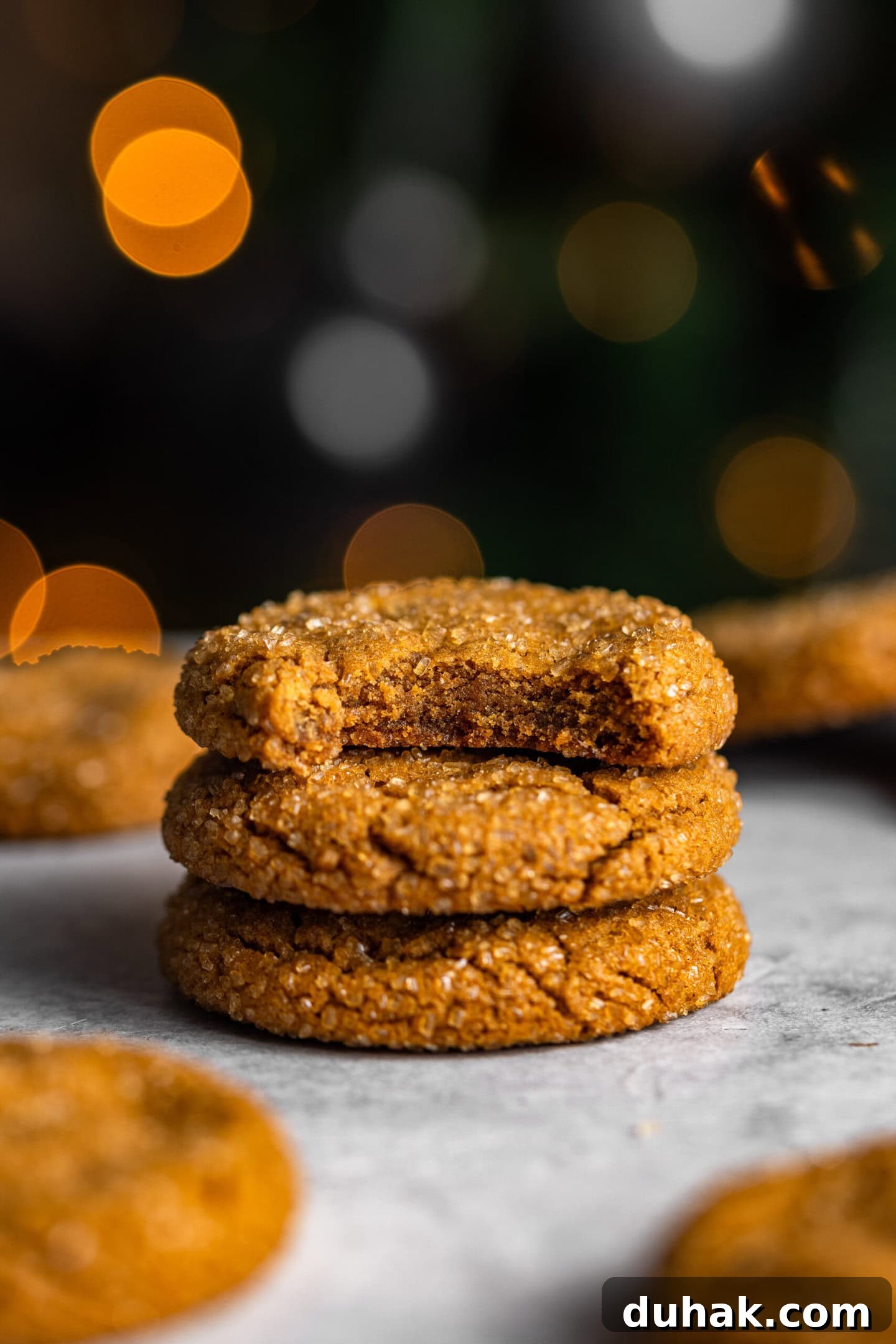 gingerbread molasses cookies stacked on top of each other with a bite missing out of one.