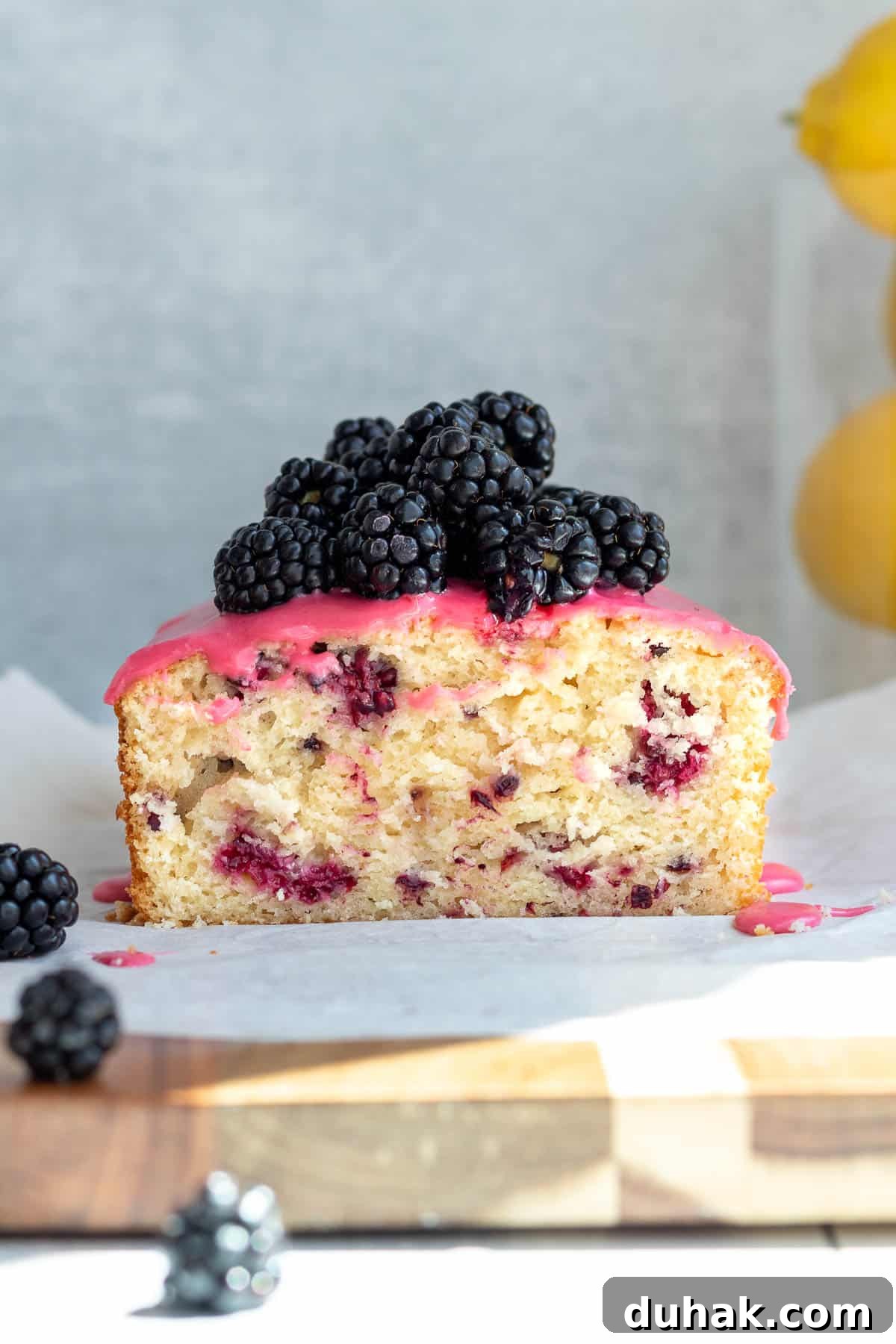 Lemon Blackberry Quick Bread Recipe for Moist Loaves 4 blackberry lemon bread with blackberries piled on top, sliced open and sitting on a wooden cutting board