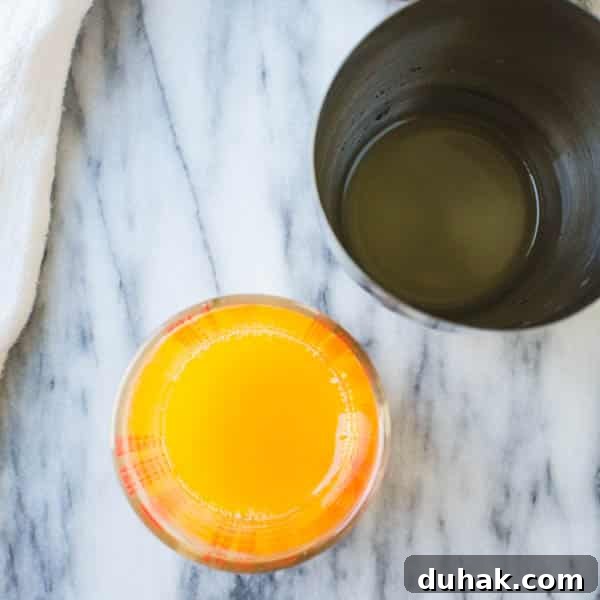 Sparkling Cara Cara Orange Margaritas — Festive Citrus Cocktail Recipe 4 orange juice in a measuring glass with a boston cocktail shaker.