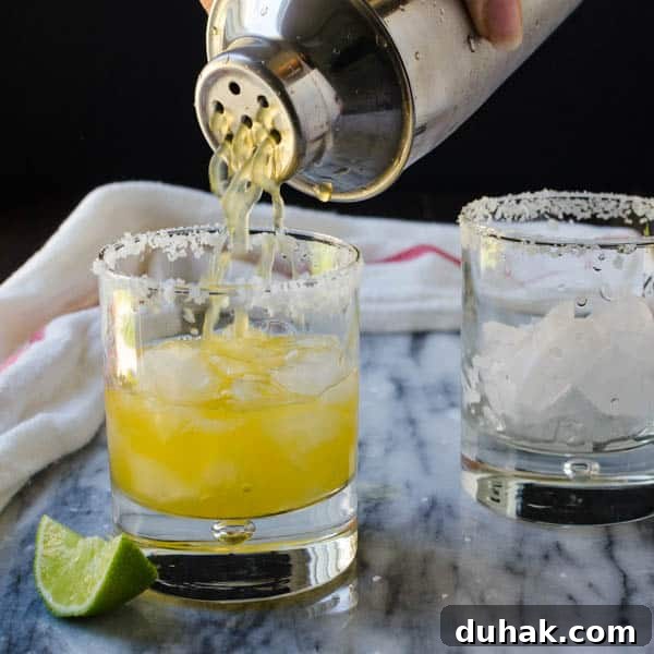 Sparkling Cara Cara Orange Margaritas — Festive Citrus Cocktail Recipe 8 straining the margaritas through a boston shaker sieve into a prepared glass