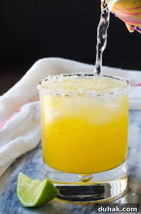 Sparkling Cara Cara Orange Margaritas — Festive Citrus Cocktail Recipe 9 adding sparkling water to the cara cara margarita.