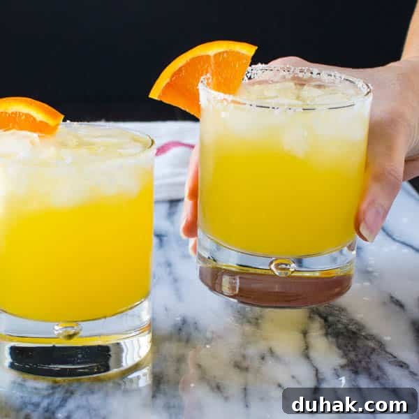 Sparkling Cara Cara Orange Margaritas — Festive Citrus Cocktail Recipe 10 a hand holding the sparkling cara cara margarita