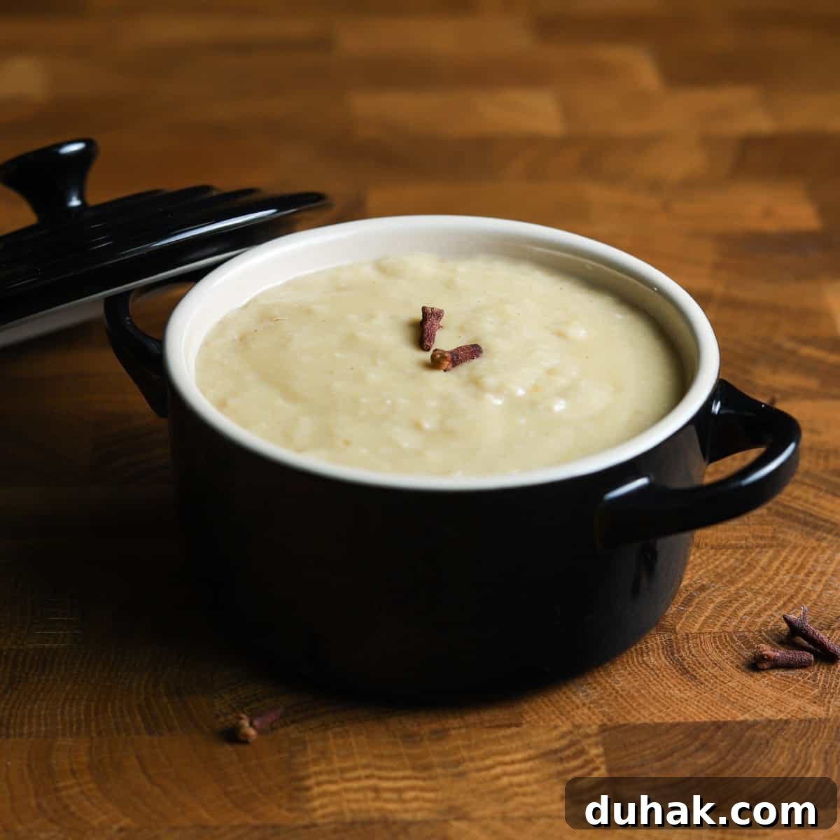 Photo of a dish of bread sauce on a wooden table.
