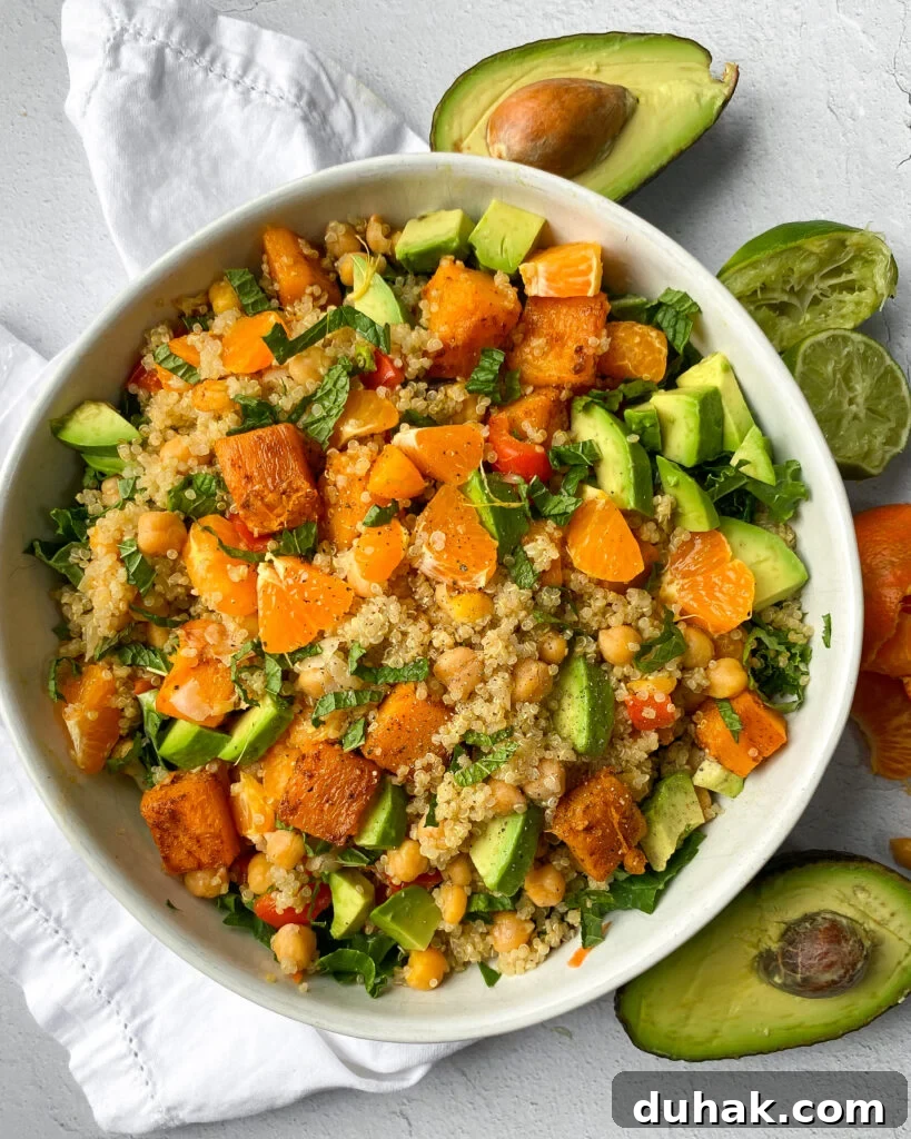 Mandarin and Kale Salad with Bright Citrus Vinaigrette 2 overhead of a white bowl containing mandarin orange and kale salad with quinoa, avocado, peppers, limes, and more.