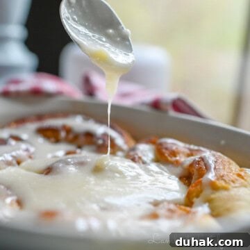 drizzling cream cheese frosting on cinnamon rolls.