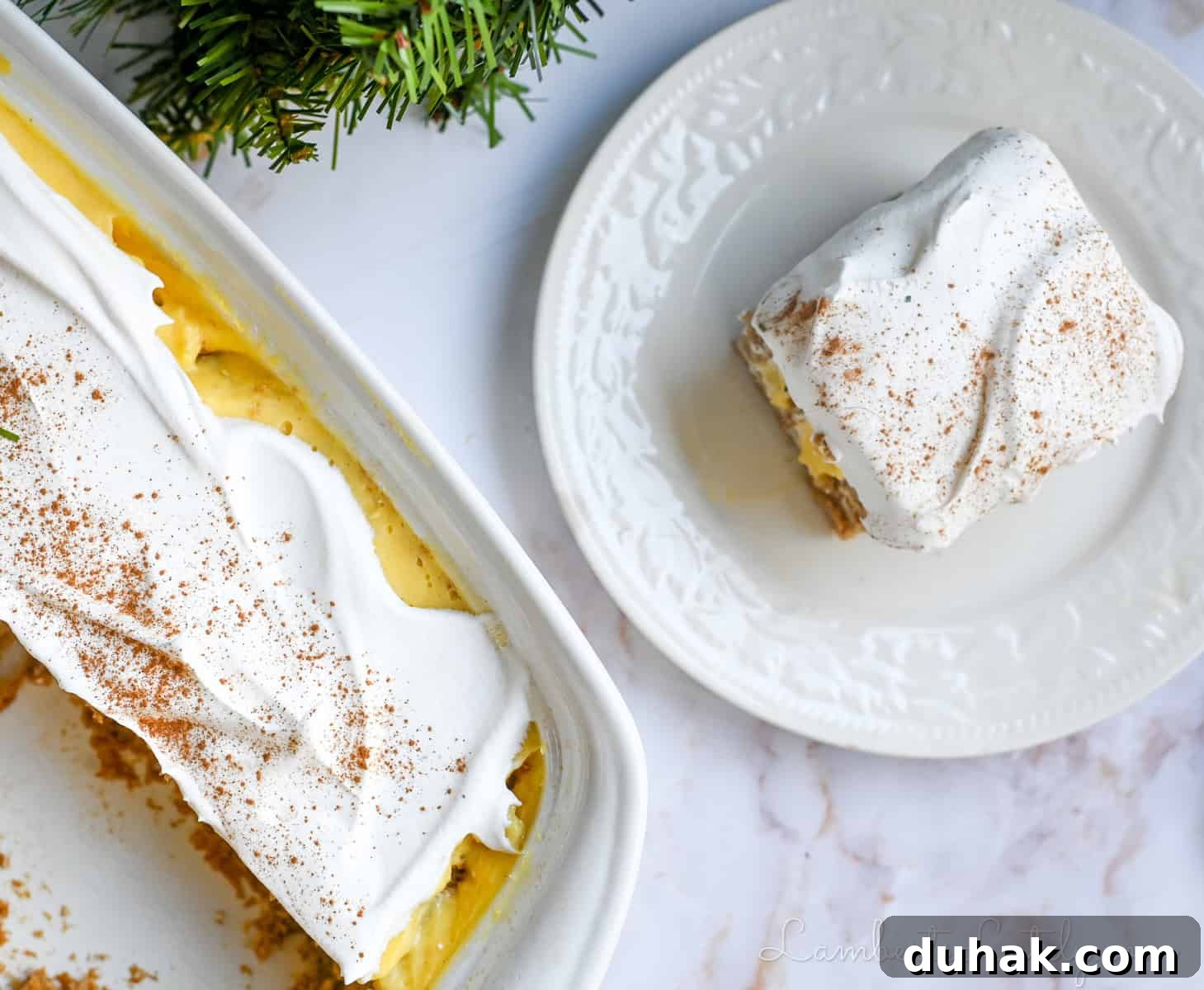 Creamy Eggnog Poke Cake Recipe for Holiday Dessert 8 a piece of eggnog poke cake on a plate, next to a baking dish of cake.