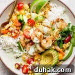 Cilantro-Lime Shrimp Bowl with Creamy Cilantro-Lime Sauce 9 Top down shot of a bowl filled with rice, cilantro lime shrimp, grilled corn salad and avocado.