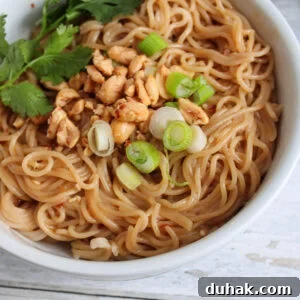 Bowl of Thai Spicy Peanut Butter Ramen with garnishes.