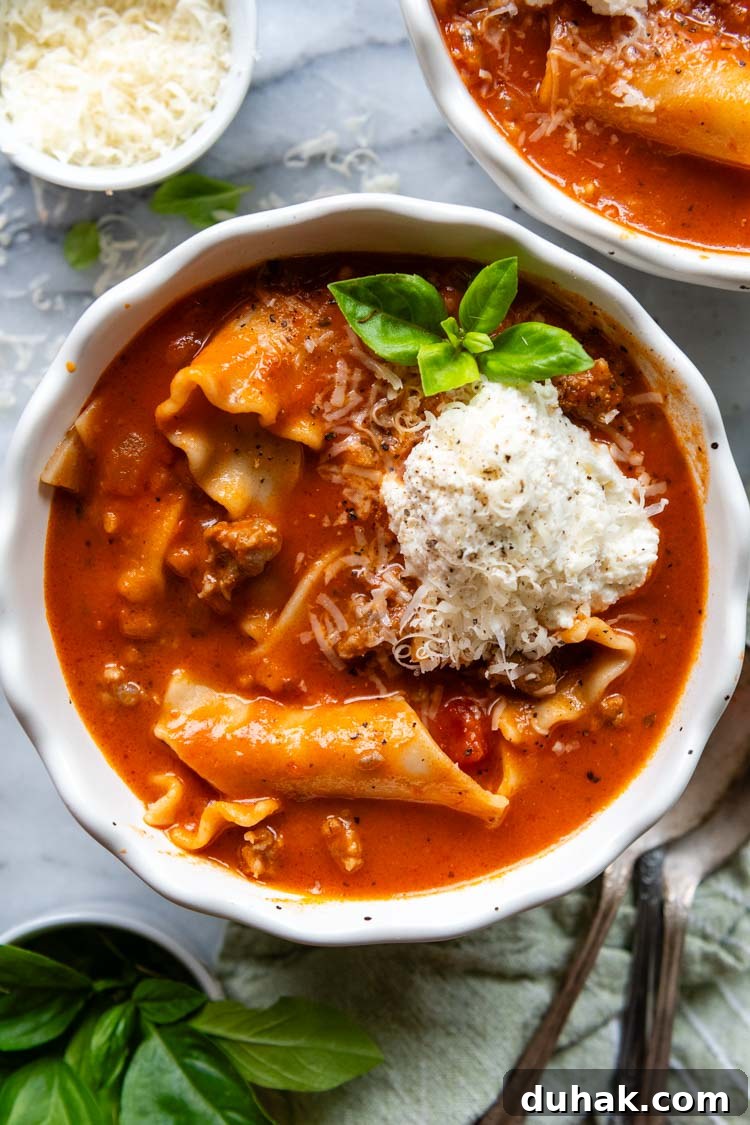 30-Minute Gluten-Free Lasagna Soup Recipe — Hearty & Homemade 6 overhead shot of completed lasagna soup in a white bowl with basil garnish.