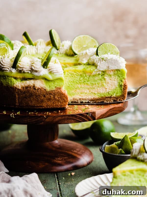 The sliced key lime cheesecake on a cake stand.