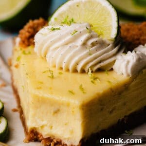 A close-up of a slice of key lime pie on a dessert plate, with a bite missing.
