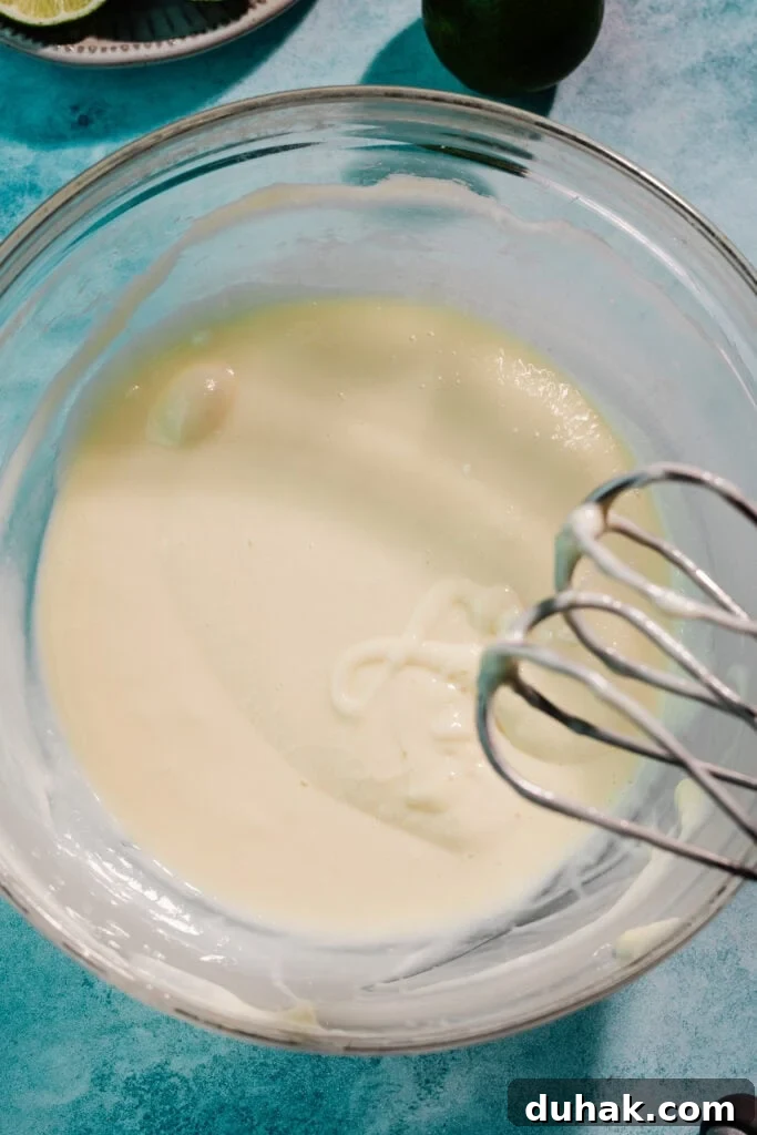 A bowl of cream cheese and sweetened condensed milk mixed together.