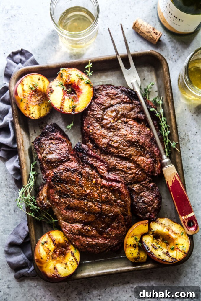 Grilled Ribeye with Caramelized Peaches and Herb Butter 2 grilled ribeye steaks with peaches www.thecuriousplate.com