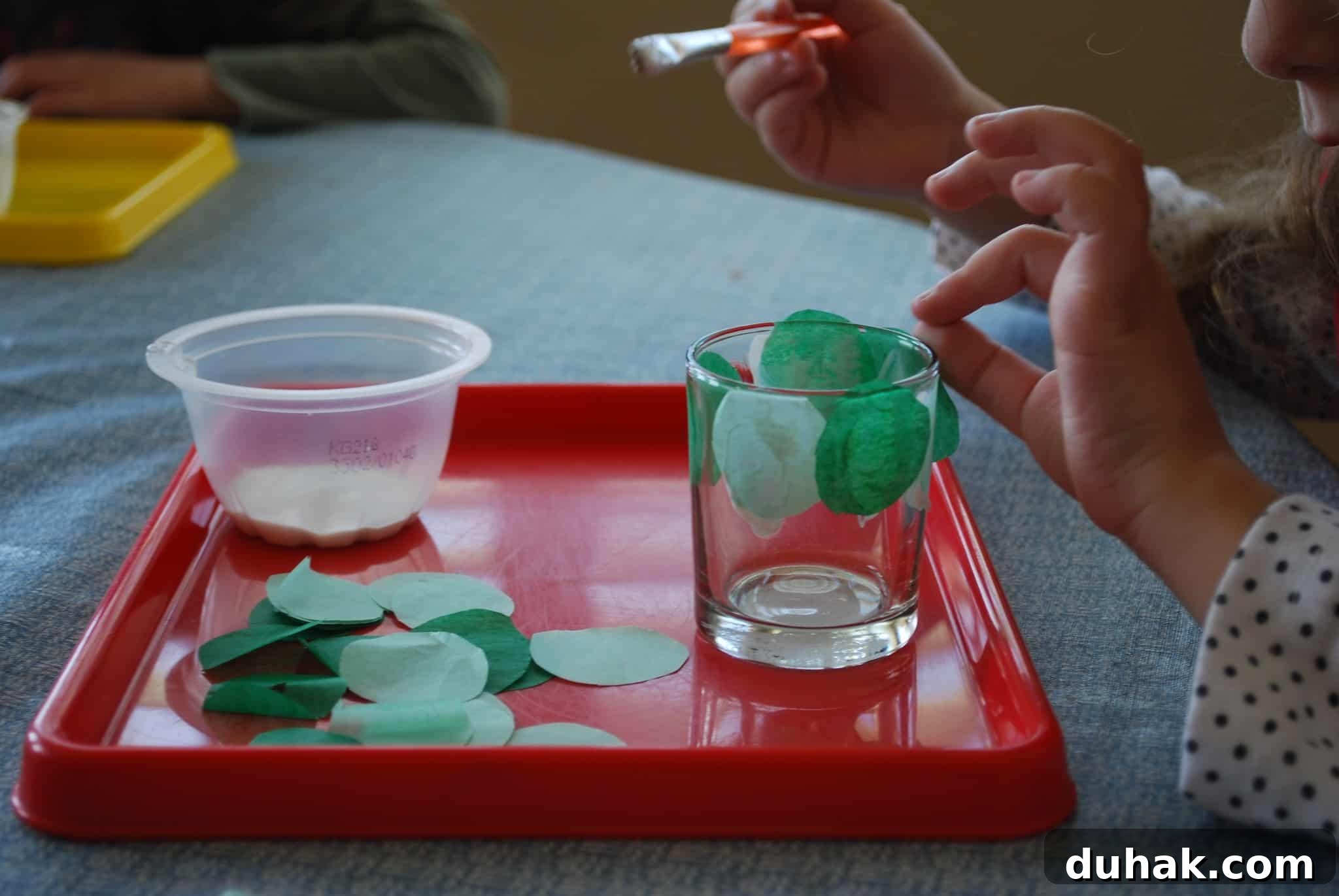St. Patrick’s Day Votive Candle Craft Ideas 6 child gluing green tissue paper circles on glass votive