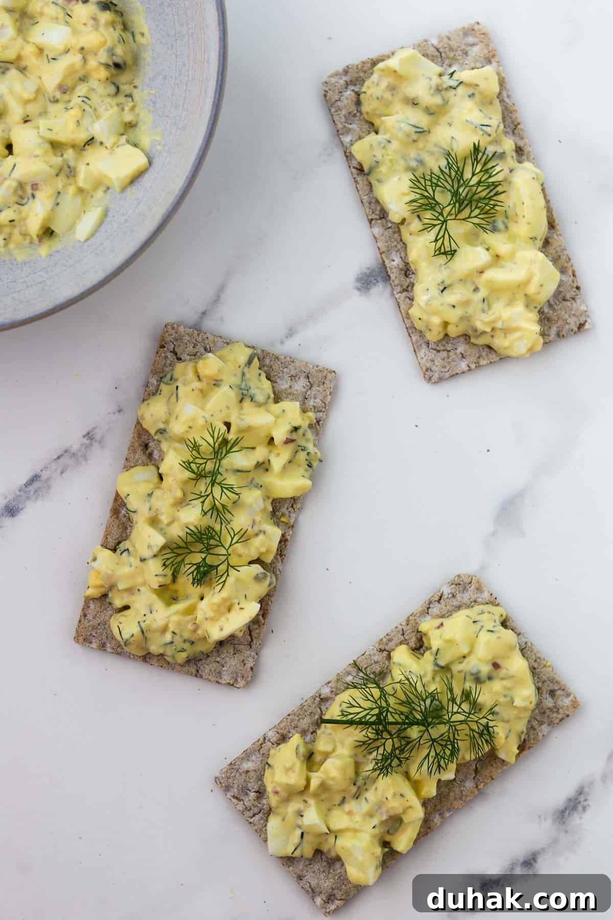 Creamy Egg Salad with Dill, Capers & Lemon Zest 13 Overhead shot of egg salad on crackers.