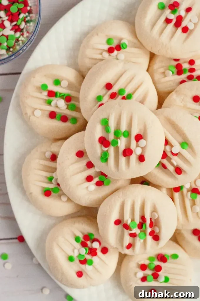 Vegan Gluten-Free Christmas Cookie Recipes 13 Perfectly round light yellow whipped shortbread cookies topped with red, white, and green confetti style sprinkles.