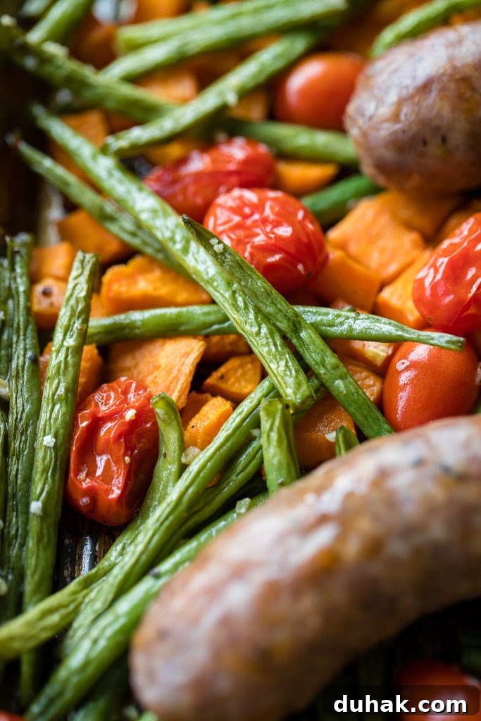 One-Pan Italian Sausage with Roasted Vegetables 7 Close-up of crinkly roasted green beans, cherry tomatoes, and sweet potatoes.