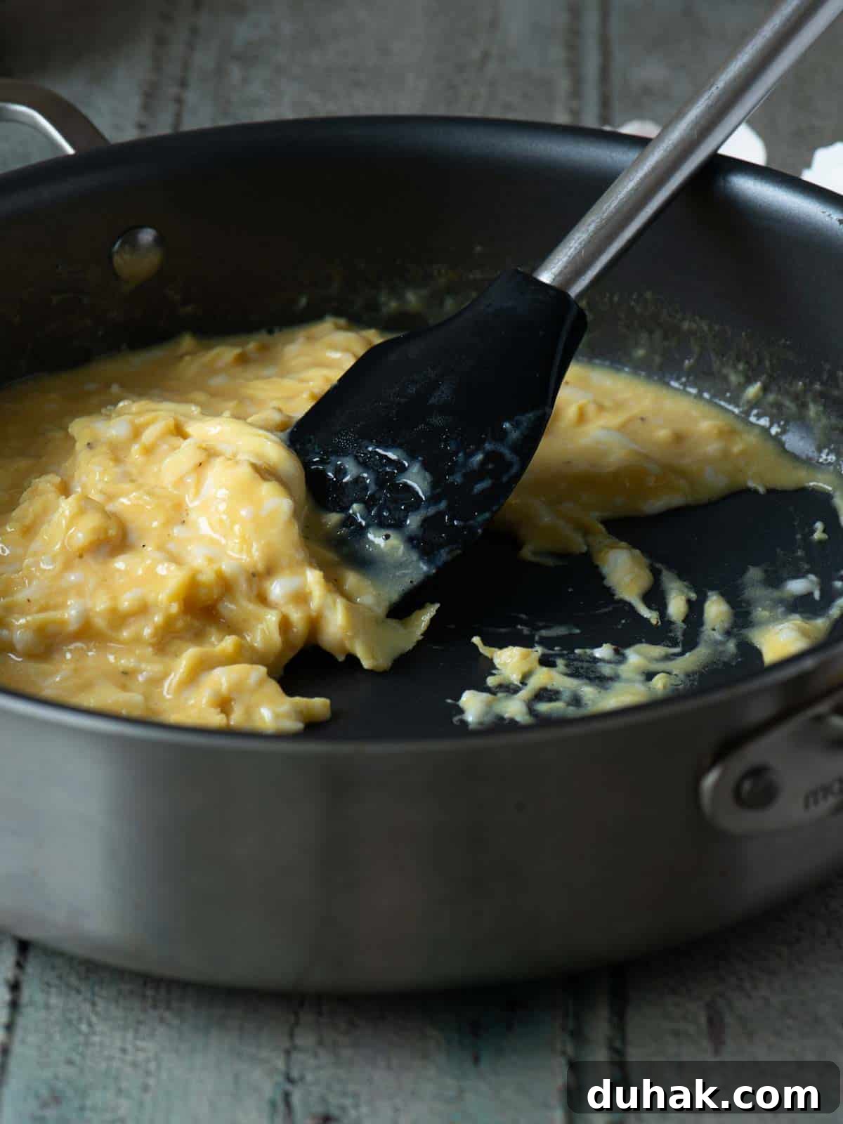 Creamy Feta and Dill Scrambled Eggs Recipe 6 Scrambled eggs being mixed in a skillet with a spatula.
