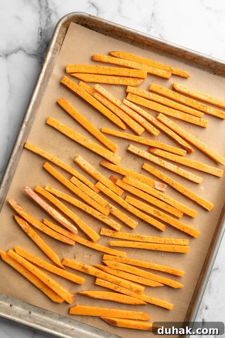 Bake until crispy Overhead view of unbaked sweet potato fries on pan