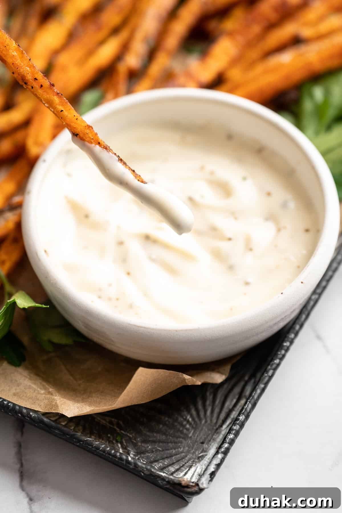 Dipping crispy sweet potato fry in sauce Dipping crispy sweet potato fry in sauce