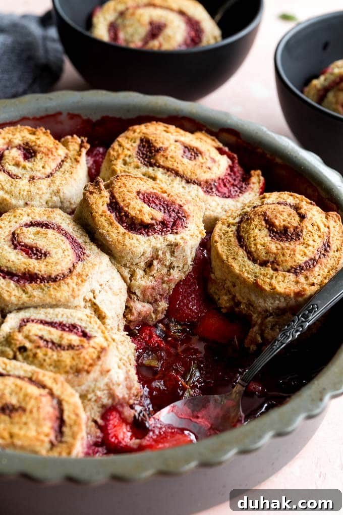 Up-close view of strawberry basil cobbler baked up in a grey pie plate.