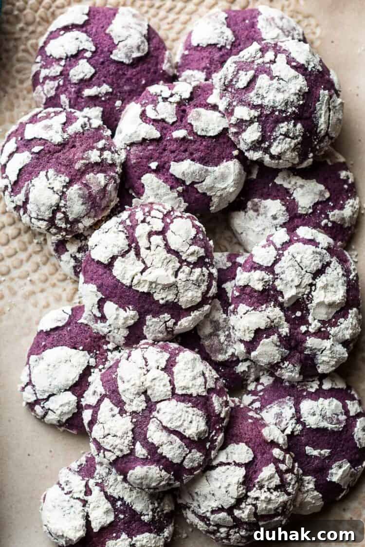 Ube Crinkle Cookies piled on a tray.