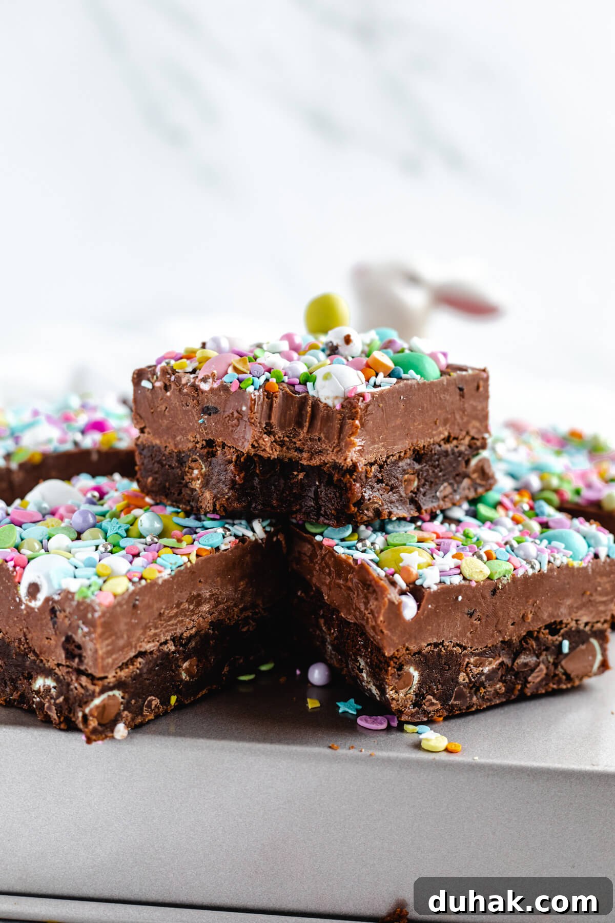 Malted Milk Chocolate Easter Egg Fudge Brownies Recipe 6 brownie with bite taken out stacked on top of two other brownies