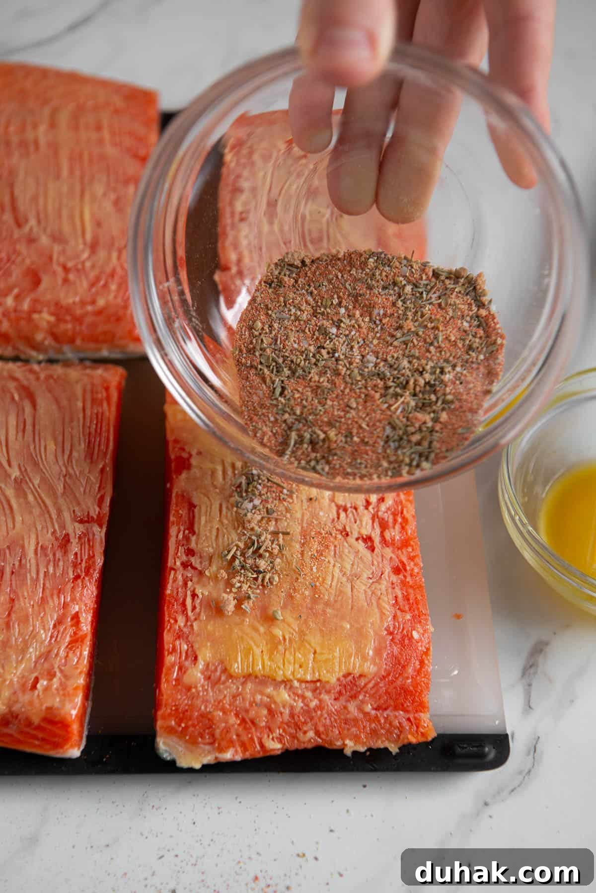 Blackened Salmon Recipe: Spicy Cajun Pan-Seared Fillets 6 Adding Cajun seasoning blend to butter brushed salmon filets.