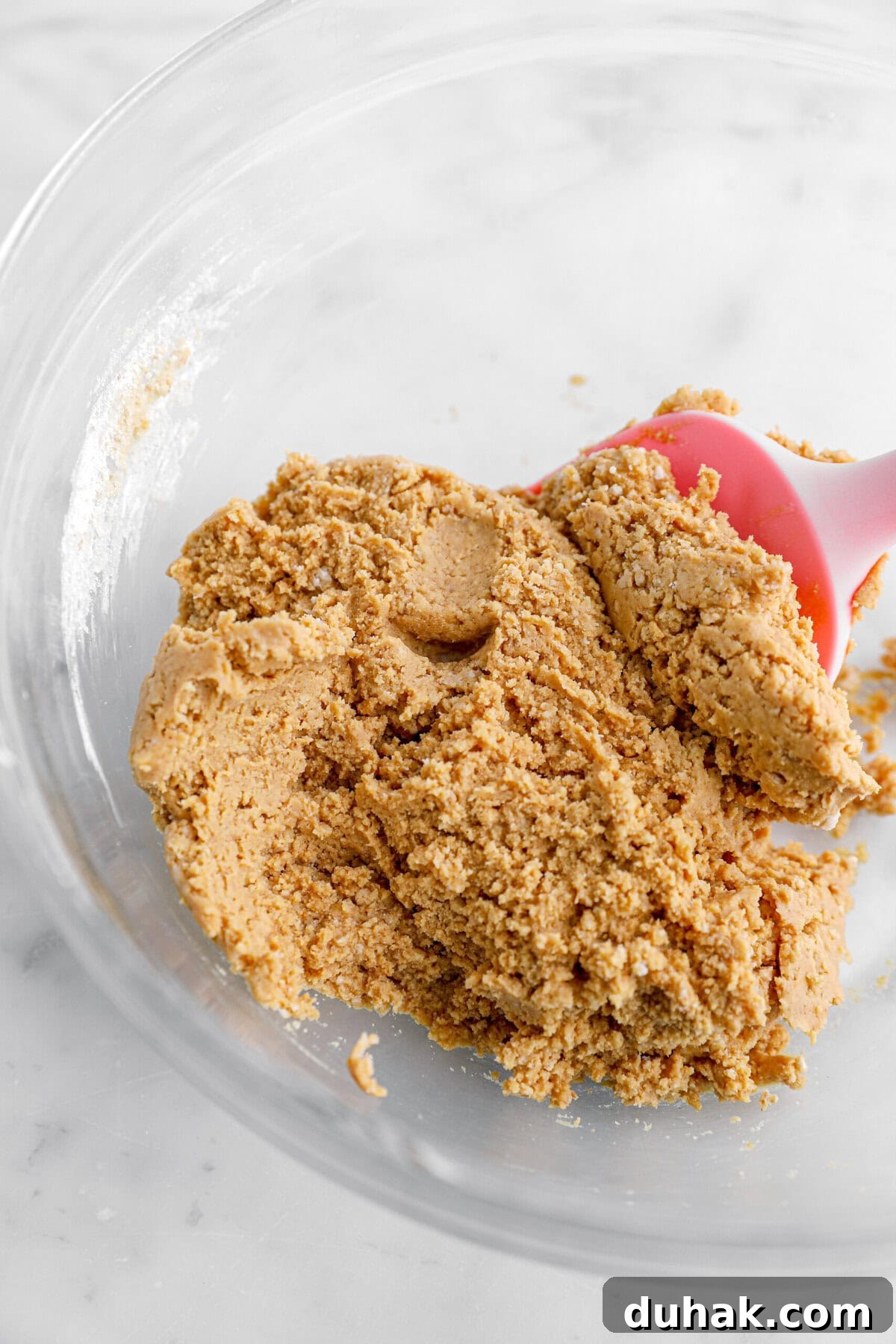 No-Bake Chocolate Peanut Butter Bars Recipe That Actually Sticks 3 peanut butter dough in glass bowl.