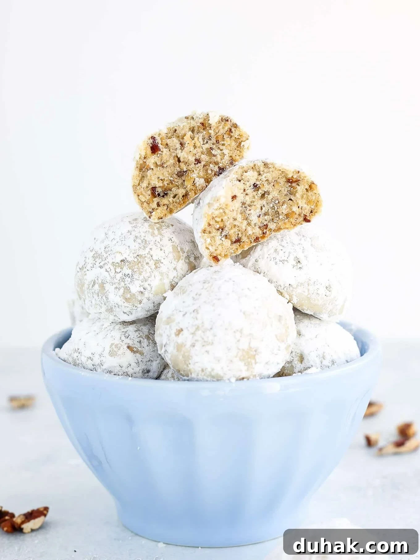 Mexican Wedding Cookies Recipe — Classic Crescent Cookies Guide 2 Mexican wedding cookies stacked in a bowl.