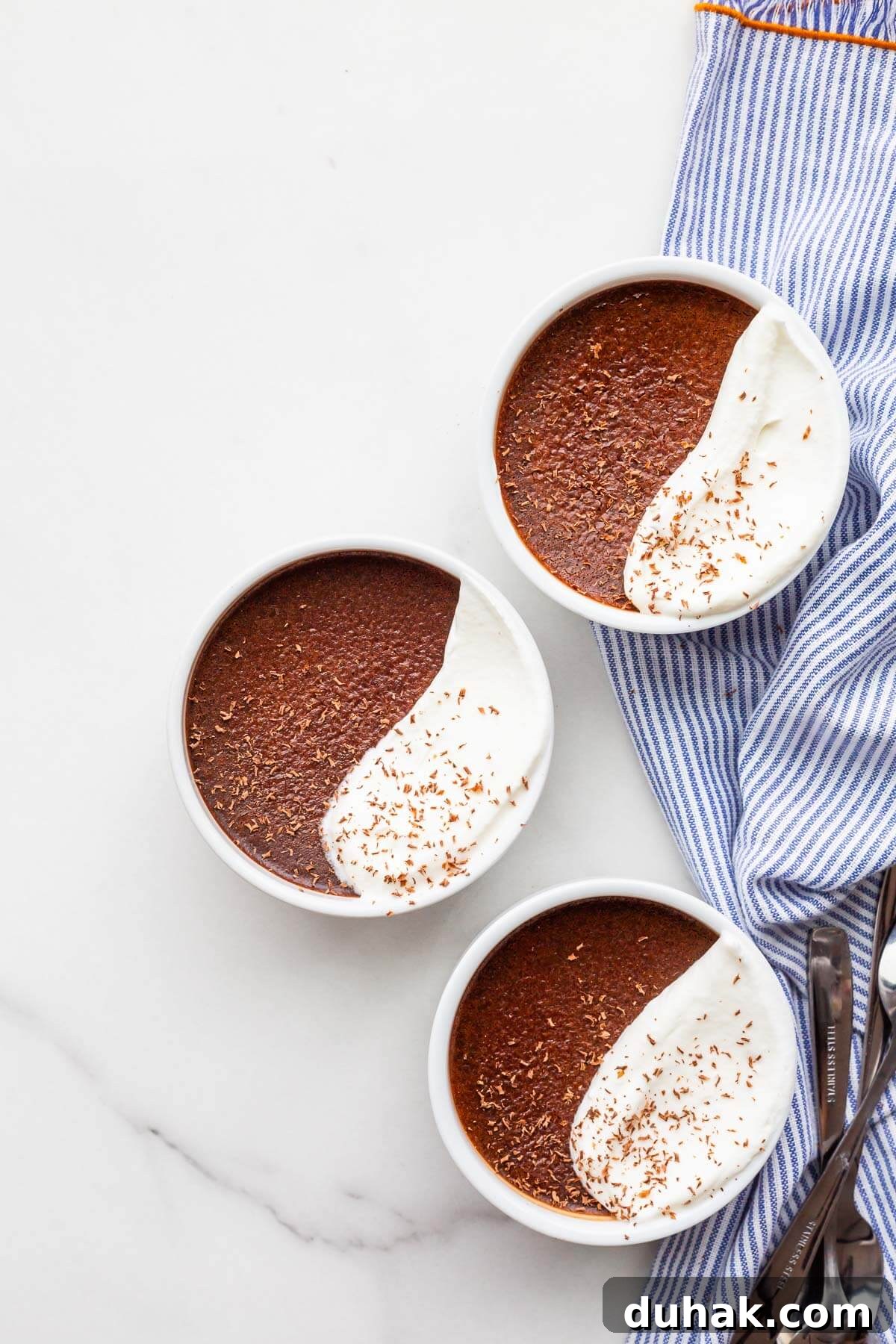 Silky Dark Chocolate Pots de Crème: Decadent French Dessert Recipe 8 Dark chocolate pots de crème desserts topped with whipped cream and grated chocolate.