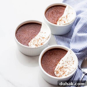Silky Dark Chocolate Pots de Crème: Decadent French Dessert Recipe 9 Ramekins of dark chocolate pots de crème topped with a dollop of whipped cream and grated chocolate.