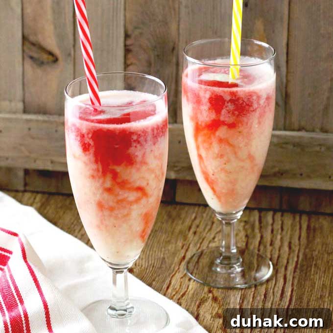 Refreshing Summer Cocktails, Mocktails & Fruity Drink Recipes 3 Two glasses of Hawaiian Lava Flow Cocktail with straws on a wooden surface