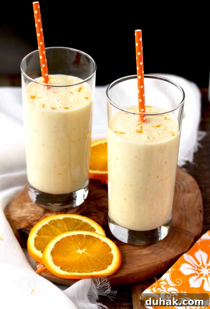 Refreshing Summer Cocktails, Mocktails & Fruity Drink Recipes 10 Pictured here two tall glasses filled with Orange Honey Lassi with two orange polka dot straws