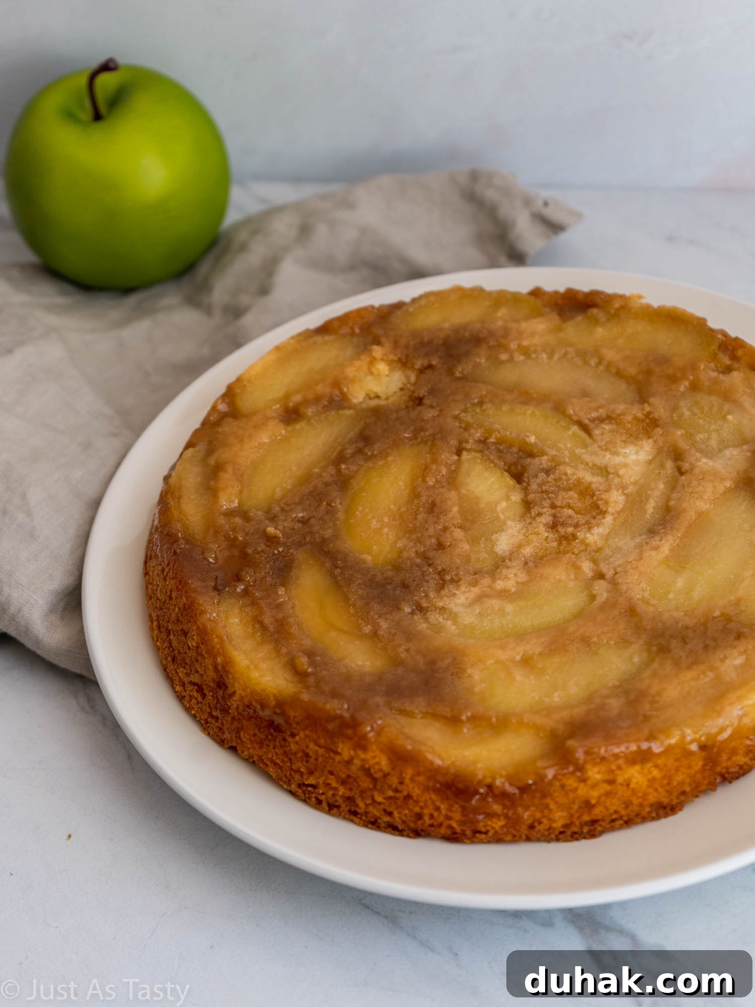 Gluten-Free Eggless Apple Cake Recipe: Moist & Simple 2 Gluten free single-layer apple cake on a white plate.