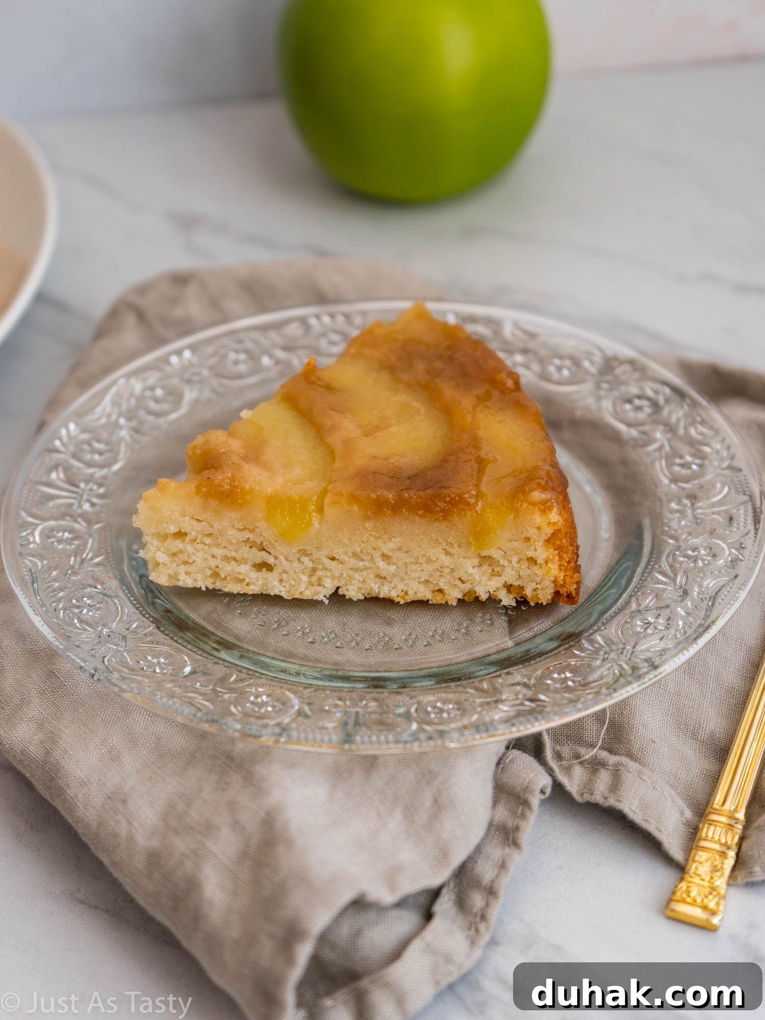 Gluten-Free Eggless Apple Cake Recipe: Moist & Simple 3 Slice of cake topped with apples on a glass plate.