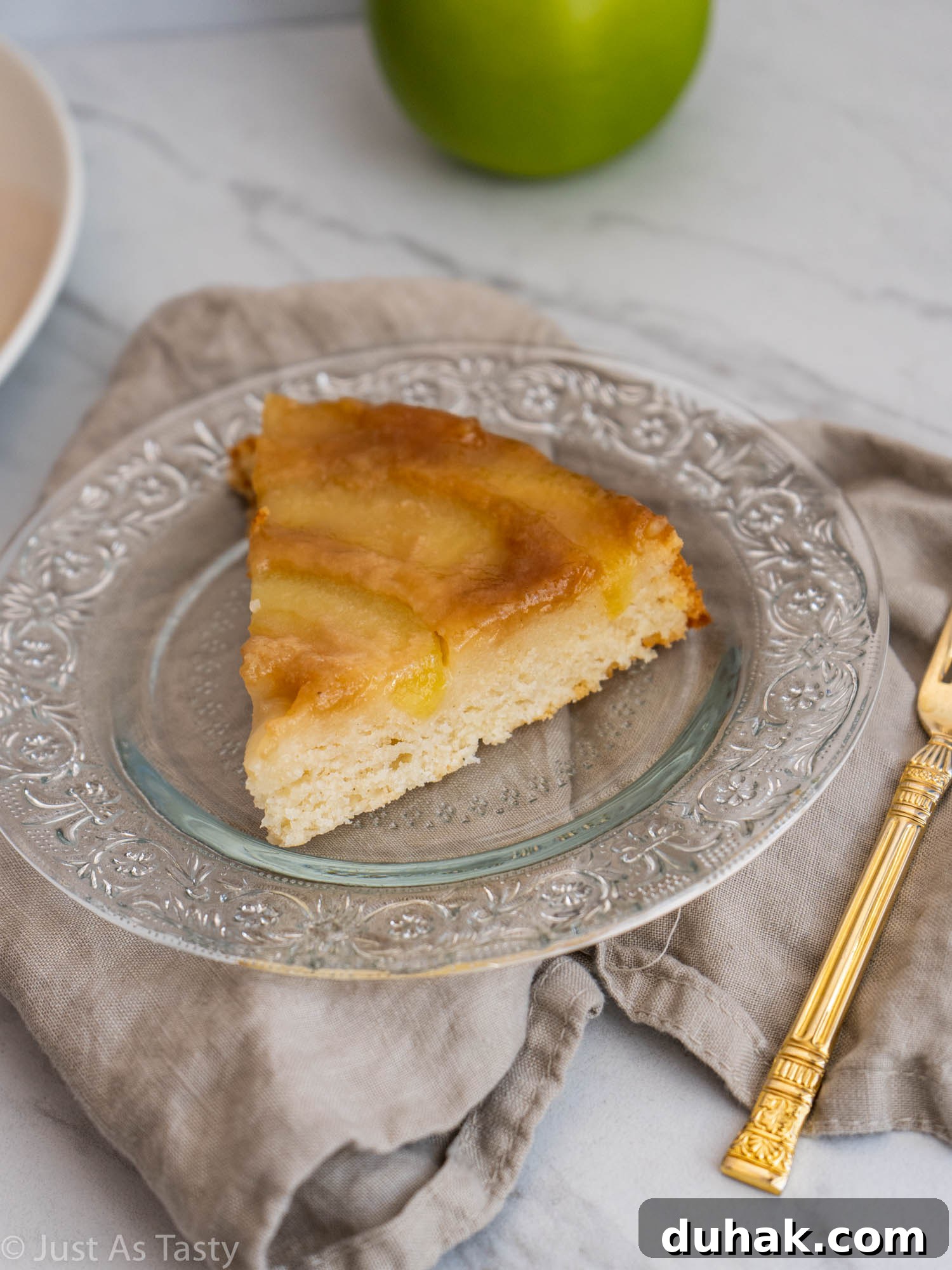 Gluten-Free Eggless Apple Cake Recipe: Moist & Simple 5 Slice of cake topped with apples on a glass plate.