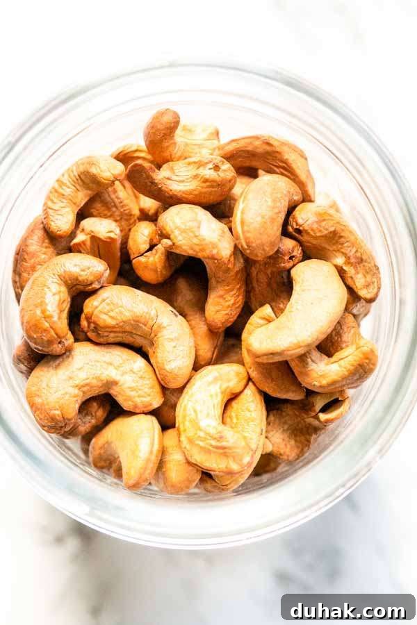 Air Fryer cashews in a glass jar. The are golden brown and crunchy and you can store them for a long time.