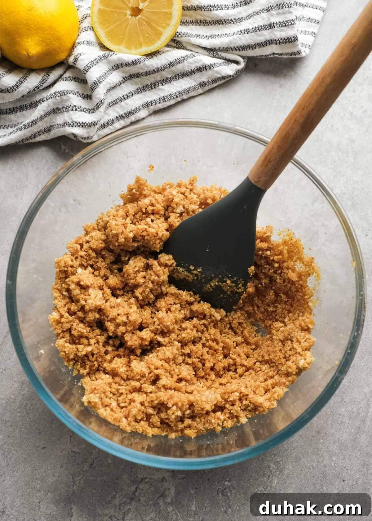 Lemon Cheesecake Recipe with Zesty Citrus Cream Filling 4 graham cracker crumbs being mixed with sugar and butter in a glass bowl