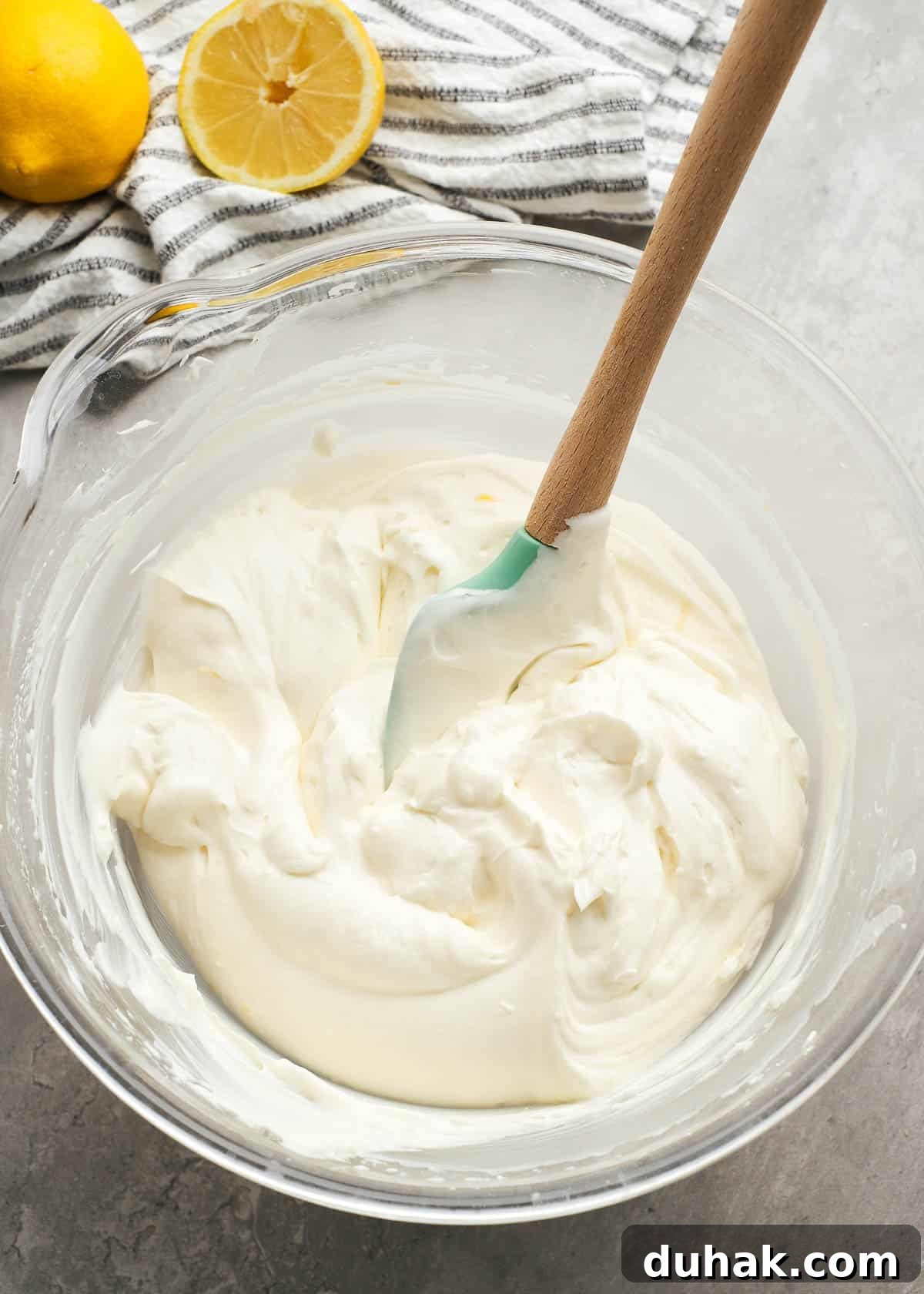 Lemon Cheesecake Recipe with Zesty Citrus Cream Filling 8 whipped cream being folded into a flavored cream cheese mixture to create a lemon cheesecake filling