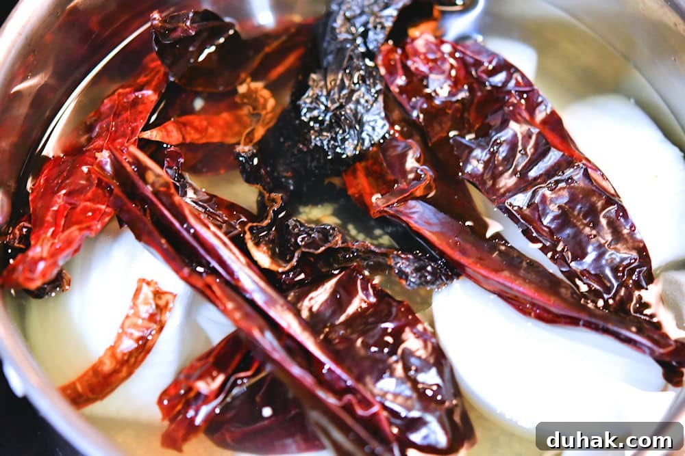 Authentic Pork Chile Colorado Asado Recipe — Savory Mexican Pork Stew 13 The dried chiles, onion and garlic are steamed in water to reconstitute them.