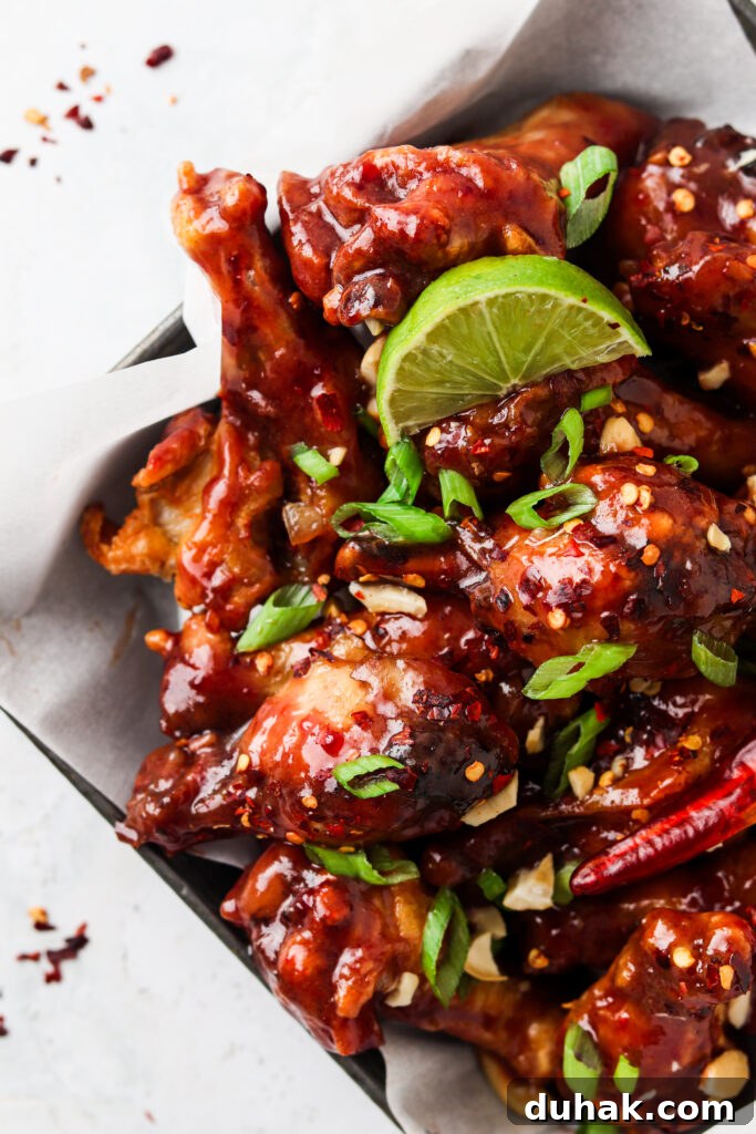 peanut butter and jelly chicken wings on a plate with limes
